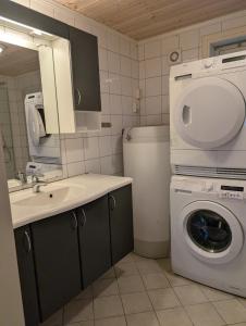 a bathroom with a sink and a washing machine at Feriehjemmet in Ringsaker