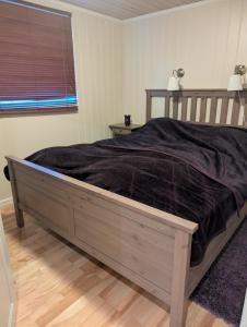 a bedroom with a large bed with a black blanket at Feriehjemmet in Ringsaker