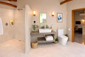 a bathroom with a toilet and a sink and a shower at Coconut Lodge Open-Plan Suite with Kitchen, Indoor & Outdoor Showers & Infinity Pool in Cap Malheureux +42 photos