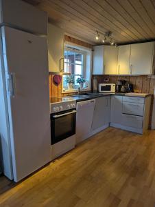 a kitchen with white appliances and a wooden floor at Feriehjemmet in Ringsaker