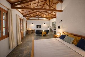 a bedroom with a bed and a living room at Coconut Lodge Open-Plan Suite with Kitchen, Indoor & Outdoor Showers & Infinity Pool in Cap Malheureux