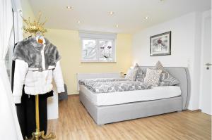 - une chambre avec un lit et un manteau sur un mannequin dans l'établissement Moseltraum-Fewo mit Klimaanlage-Burgblick und Balkon, à Bernkastel-Kues