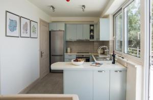 a kitchen with white cabinets and a sink at Villa Alexa in Gaios