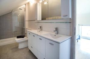 a white bathroom with a sink and a toilet at Villa Alexa in Gaios +10 photos