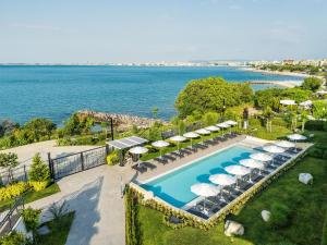an aerial view of a pool with umbrellas and the ocean at Voya Beach Resort - Ultra All Inclusive in Sveti Vlas