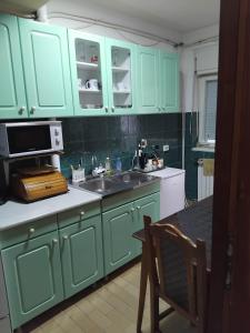 a kitchen with mint green cabinets and a sink at Apartment TiBi in Kumanovo +3 photos