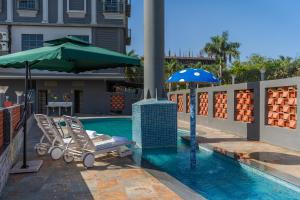 a swimming pool with a chair and an umbrella at Perfectstayz premium stepwell by the lake in Udaipur