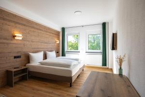 a bedroom with a bed and a large window at Schmitt Bräu - Hotel und Brauereigasthof in Scheßlitz