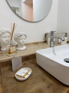 a bathroom with a white sink and a mirror at Monica's home in Ariccia +40 photos