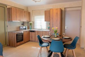 a kitchen with a wooden table and blue chairs at Amnia Villas with Private Pool in Kapsalianá +36 photos