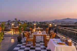 a restaurant with tables and chairs on a roof at Perfectstayz premium stepwell by the lake in Udaipur
