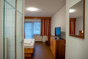 a hospital room with a bed and a television at Braugast Kreuz in Frastanz