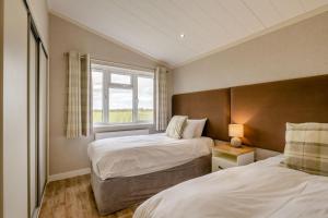 a bedroom with two beds and a window at Primrose 2 bed - Violet in Eye