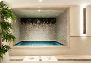 a swimming pool in a room with a shower at Grand Powers Hotel in Paris