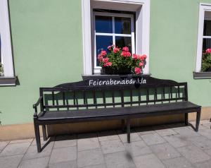 a bench sitting in front of a window with flowers at Schmitt Bräu - Hotel und Brauereigasthof in Scheßlitz