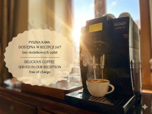 a coffee maker is making a cup of coffee at Amber Boutique Hotels - Amber Design in Krakow