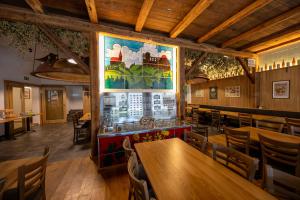 a restaurant with tables and chairs and a large painting on the wall at Schmitt Bräu - Hotel und Brauereigasthof in Scheßlitz
