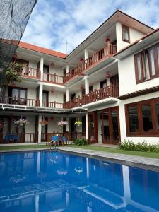 a hotel with a swimming pool in front of a building at Village Moon Villa in Hoi An