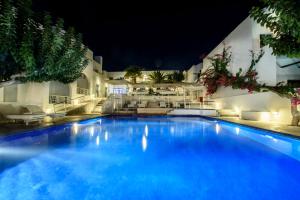 a large swimming pool with blue water at night at RK Beach Hotel in Kamari