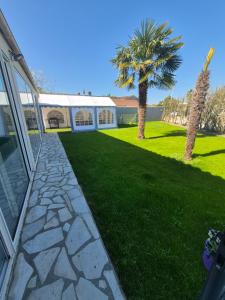 a house with a stone walkway next to a yard at Gîte OL'HERON familiale pour 9 personnes à Dolus in Dolus-d'Oléron