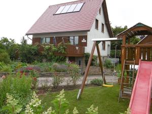 a house with a playground in the yard at Ferienwohnung Meyer in Ilmenau
