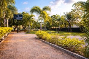 a park with palm trees and a sign in the middle at Aqua Hotel Yala in Yala