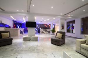 a living room with couches and a flat screen tv at RK Beach Hotel in Kamari