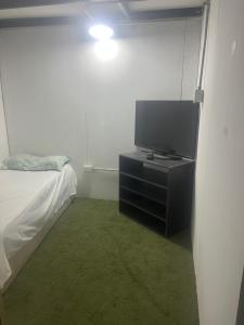 a bedroom with a tv on a dresser next to a bed at Duval in Calama