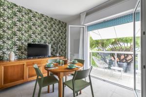 a dining room with a table and chairs and a television at Harvey Suites Hotel & Residence in Lido di Jesolo