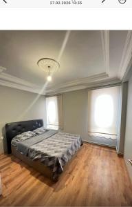 a bedroom with a bed in a room with two windows at Fortuna House in Ankara