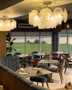 a restaurant with tables and chairs and large windows at The Cliff Hotel & Spa in Cardigan