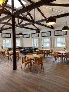 a large room with tables and chairs and windows at Rørvig Centret in Rørvig
