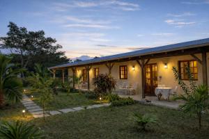 a house with a table and chairs in a yard at Vanilla Lodge Tropical Garden Suite with Outdoor Stone Bath & Bamboo Shower, inifinity pool in Cap Malheureux