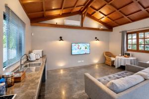 a living room with a couch and a table at Vanilla Lodge Tropical Garden Suite with Outdoor Stone Bath & Bamboo Shower, inifinity pool in Cap Malheureux