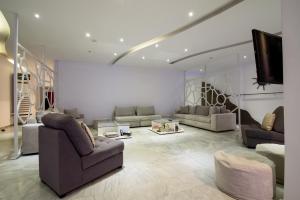 a living room with couches and a flat screen tv at RK Beach Hotel in Kamari