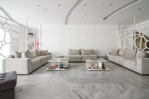 a living room with couches and books on the floor at RK Beach Hotel in Kamari