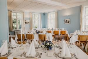 a room full of tables and chairs with white tablecloths at Rørvig Centret in Rørvig