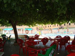 un grupo de mesas y sillas junto a una piscina en Alpen1 Peñiscola Residencial, en Peñíscola