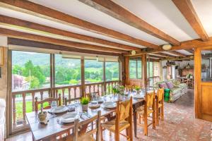 a dining room with a table and chairs and a balcony at Casa Arozenia, Hogar rústico en pleno valle Ulzama in Lizaso