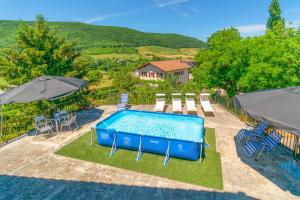 a pool with chairs and a table and an umbrella at Casa Arozenia, Hogar rústico en pleno valle Ulzama in Lizaso