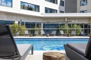 a swimming pool with chairs and a building at Hotel SB Icaria in Barcelona