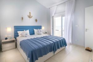 a bedroom with a large bed with a blue blanket at Villa Ariadne in Achlia +18 photos