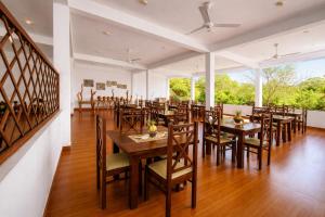 a dining room with wooden tables and chairs at Aqua Hotel Yala in Yala