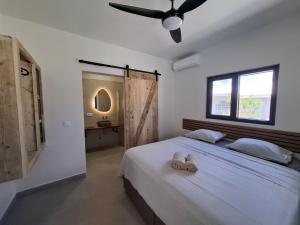 a bedroom with a white bed with a ceiling fan at Emma Luxury Pool Suites Resort in Willemstad +101 photos