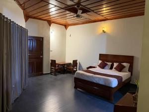 a bedroom with a bed and a table and a door at Deva Maani Coorg Nature View in Madikeri +50 photos