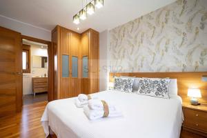 a bedroom with a white bed with towels on it at Martinica By Silastur in Ferrera
