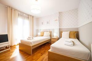 two beds in a room with a tv at Martinica By Silastur in Ferrera