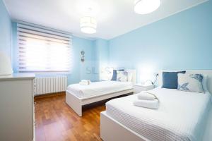two beds in a room with blue walls and wooden floors at Martinica By Silastur in Ferrera
