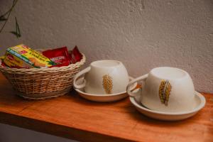 two cups and a basket on a wooden table at Villa Carlos Tangalle in Tangalle