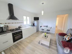 a kitchen and living room with a couch and a table at Les 3 métisses-lyia in Le Bugue +5 photos